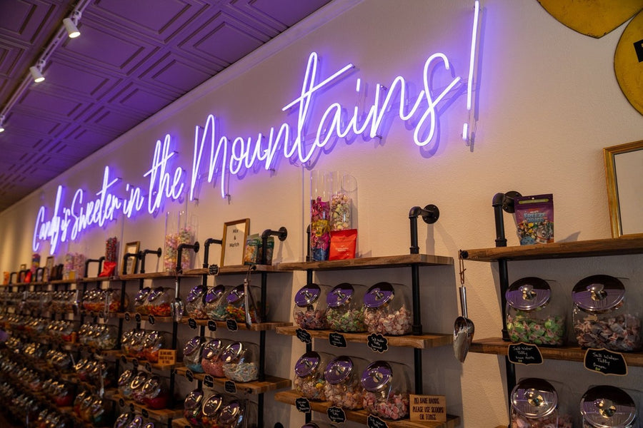 Salida shop with jars of bulk candy under a purple neon sign